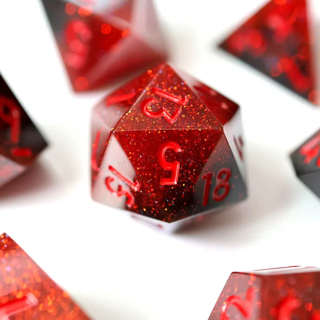 Close-up of a red and black glitter-flecked D20 with red numerals.