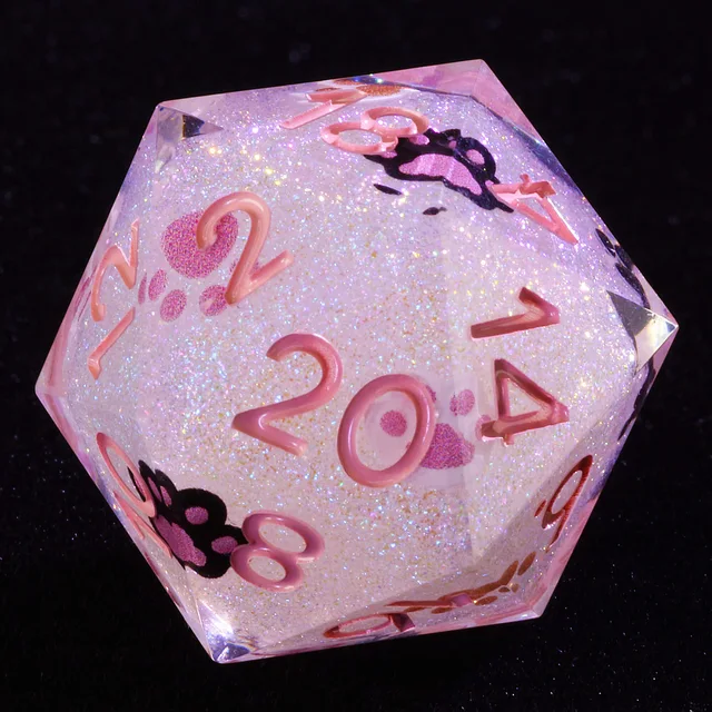 Close-up of glittery pale pink D20 with pink numbers and cat paw prints.