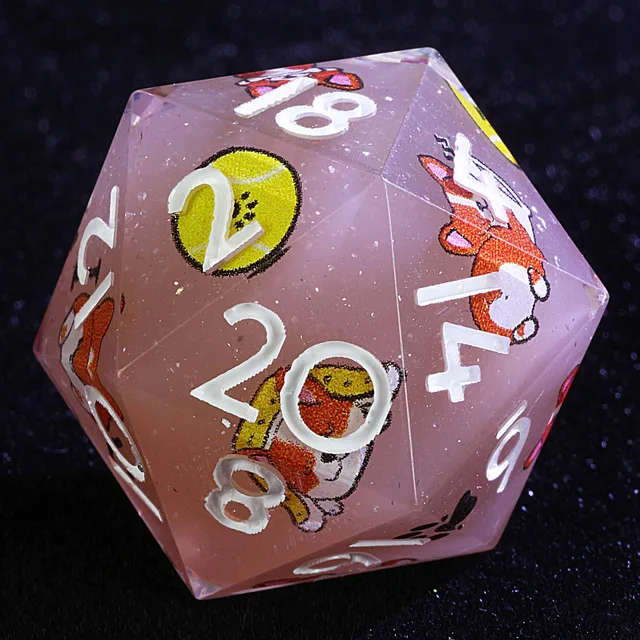 Close-up of a translucent pink D20 with white numbers and corgi illustrations.