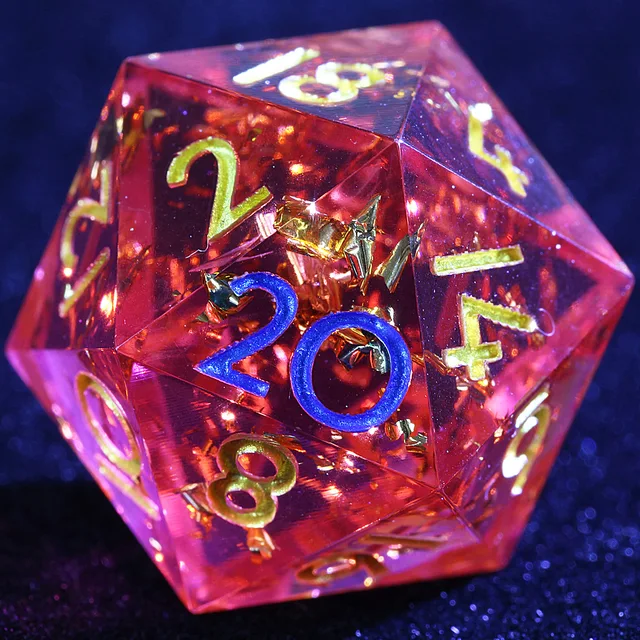Close-up of a translucent crimson-pink D20 with gold flecks and blue and gold numerals.