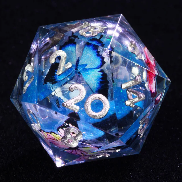 Close-up of clear D20 with a blue butterfly, blue core and silver-coloured numbers.