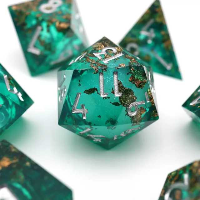 Close-up of a teal-green D20 with gold-toned flakes and silver numbers.
