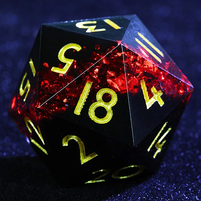 Close-up of a dark D20 with red foil-like inclusions and gold-coloured numerals.