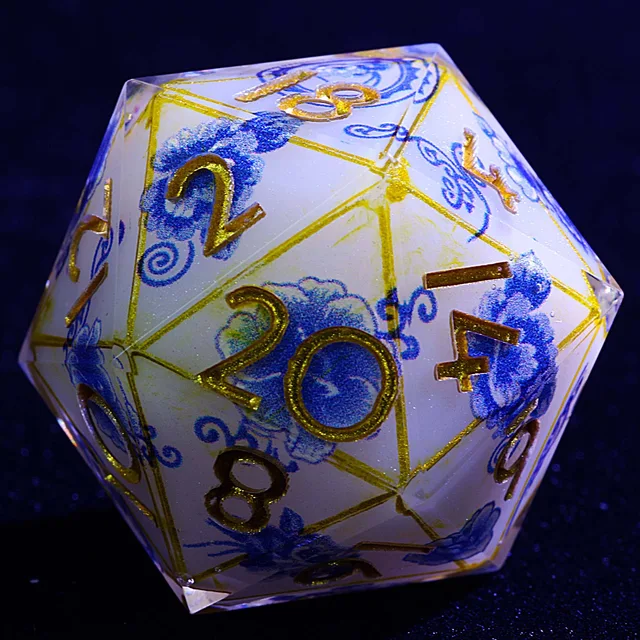 Close-up of a white D20 with blue flowers, gold borders and gold numbers.
