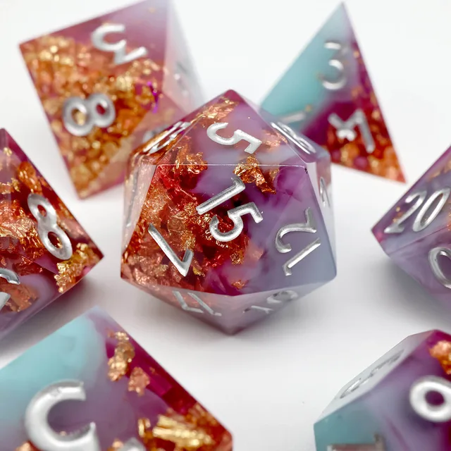 Close-up of a purple and pale blue D20 with copper-gold flakes and silver numbers.