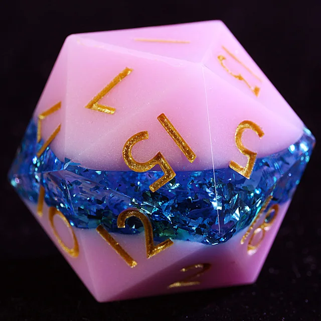 Close-up of a pink D20 with a sparkling blue foil band and gold numbers.