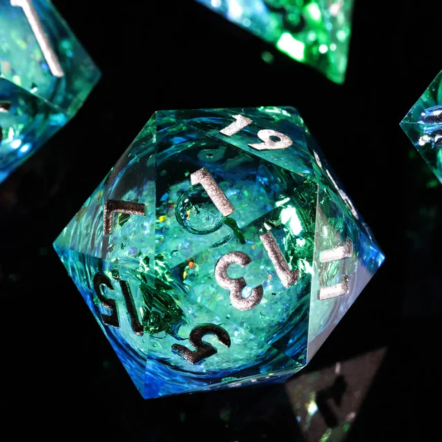 Close-up of a blue and green liquid-core D20 with silver-coloured numbers.
