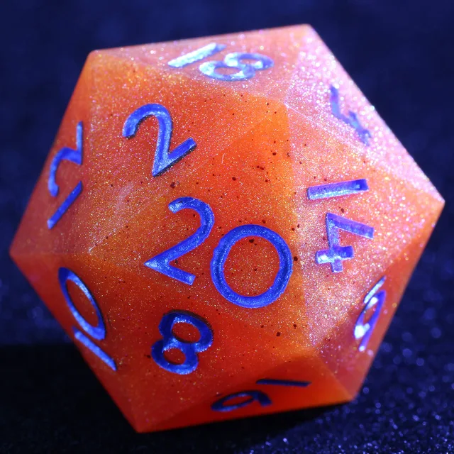 Close-up of a glittery orange D20 with blue numbers.