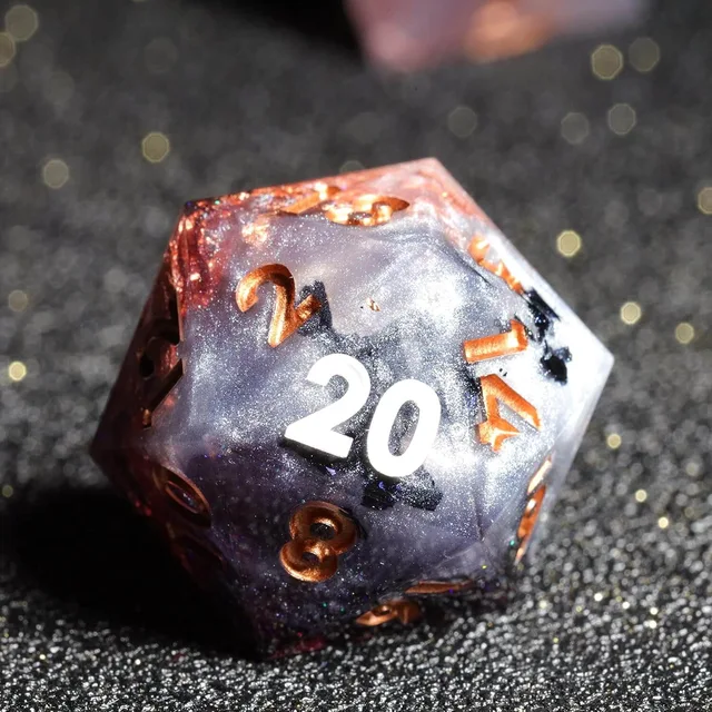 Close-up of a glittery purple and silver D20 with copper numerals.