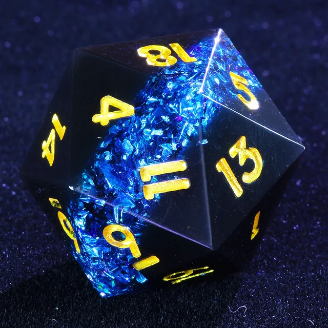Close-up of a black D20 with shimmering blue inclusions and gold numbers.