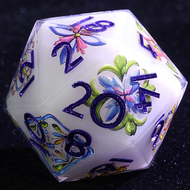 Close-up of a white-faced D20 with purple numbers and colourful floral designs.