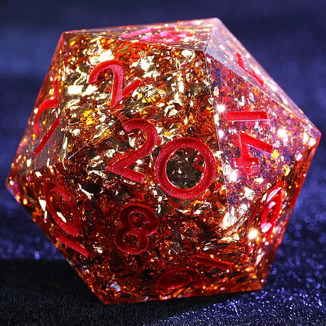 Close-up of an amber foil-filled D20 with pink-red numbers.