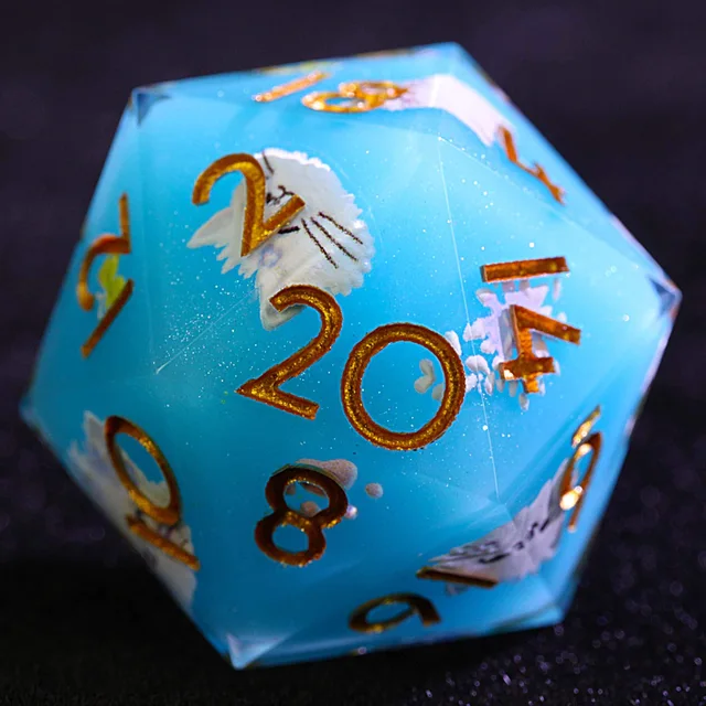 Close-up of a blue D20 with gold numbers and white cat and floral details.
