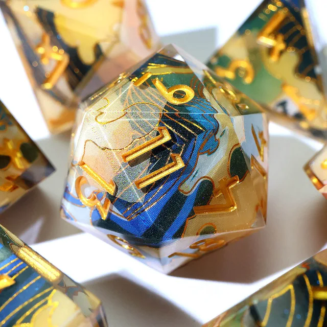 Close-up of a patterned die with gold numbers and blue-green flowing lines.