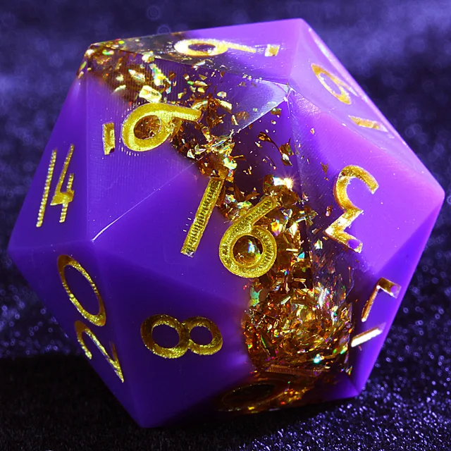 Close-up of a purple polyhedral die with gold numbers and a glittering gold-flake band.