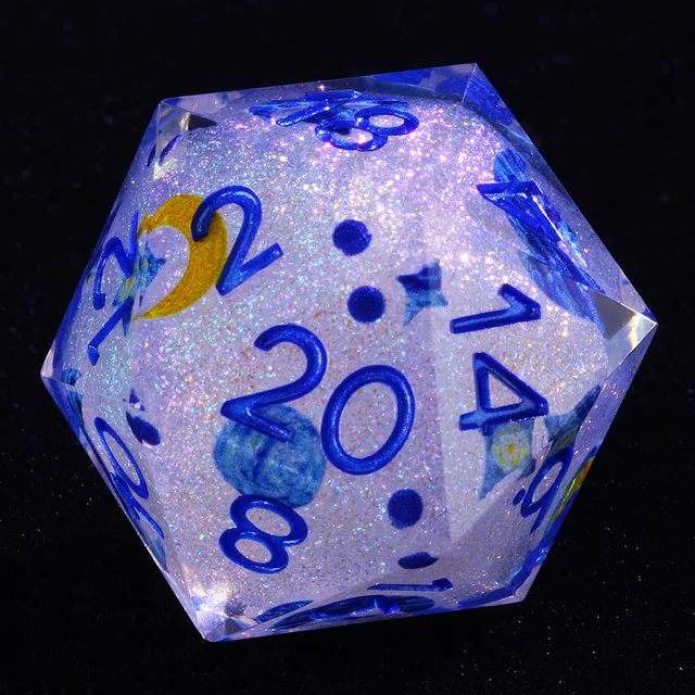 Close-up of a clear glitter-filled D20 with blue numbers and starry blue and yellow accents.