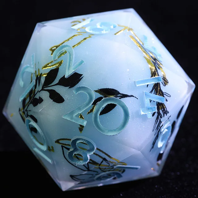 Close-up of a pale blue-white D20 with blue numerals and black-and-gold botanical details.