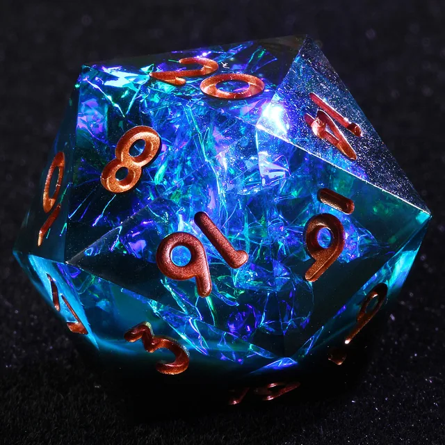 Close-up of a blue D20 with iridescent inclusions and copper-coloured numbers.
