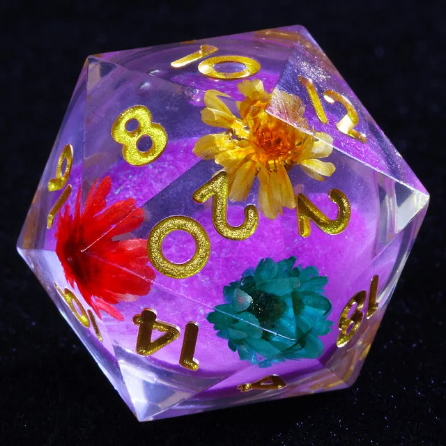 Close-up of a clear D20 with purple core, gold numbers and colourful flower-like inclusions.