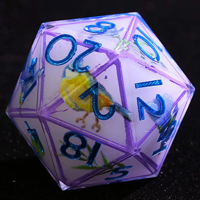 Close-up of a lavender D20 with metallic blue numbers and a yellow-and-blue bird design.