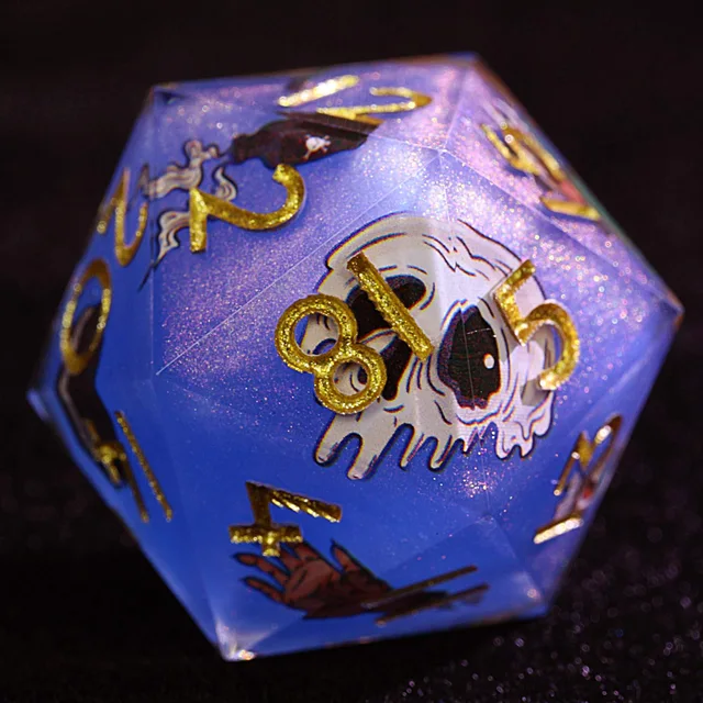 Close-up of a blue-violet glitter die with gold numbers and a white skull illustration.