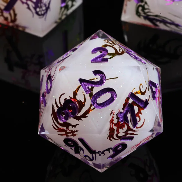 Close-up of a dragon-pattern D20 with purple numbers.