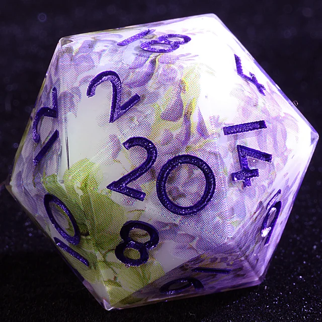 Close-up of a translucent floral-patterned D20 with purple numbers.
