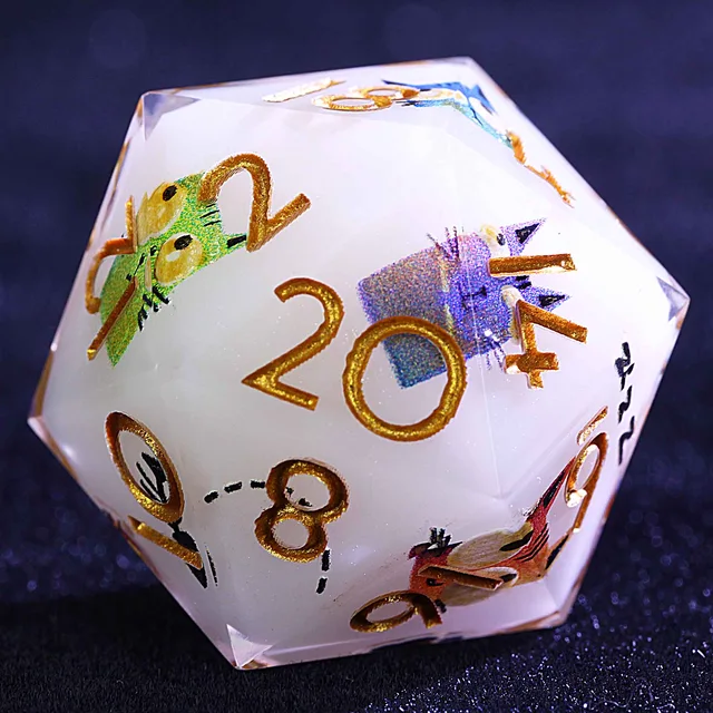 Close-up of a white D20 with gold numbers and colourful cat illustrations.
