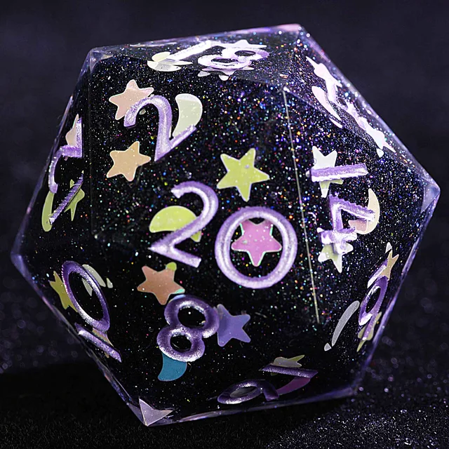 Close-up of the glittery dark D20 with lavender numbers and pastel star and crescent-moon details.