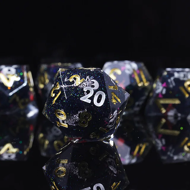Close-up of a black glitter D20 with skeleton designs and gold and white numerals.