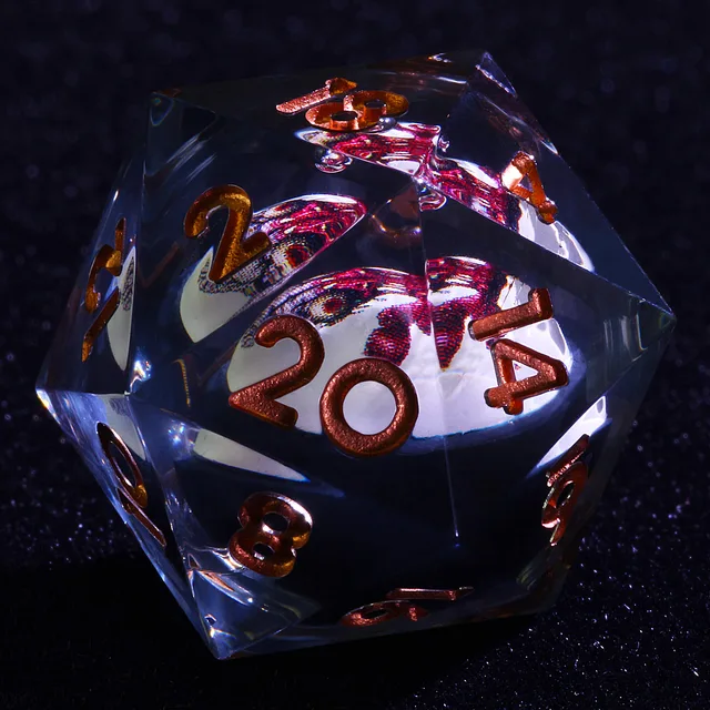 Close-up of a clear D20 with copper-coloured numbers and a red illustrated core.