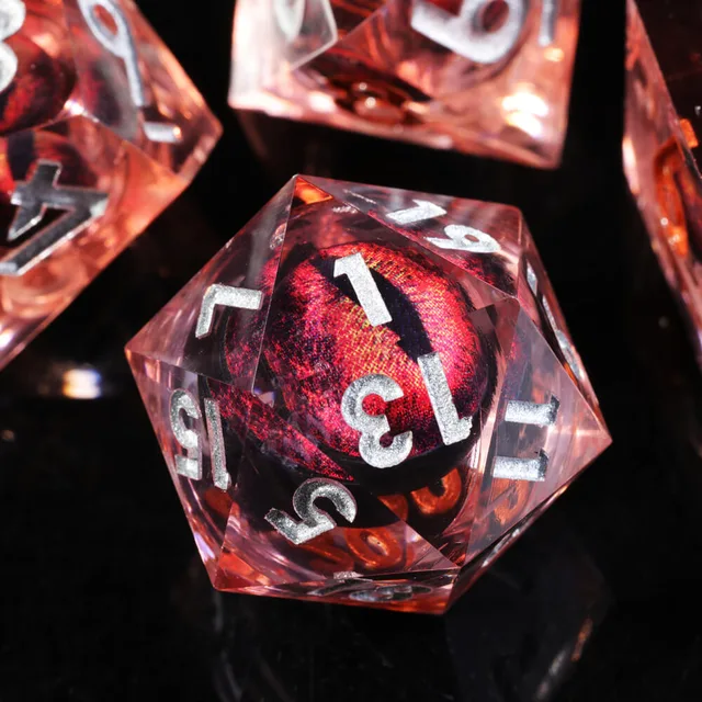 Close-up of a transparent red D20 with a dark slit-eye centre