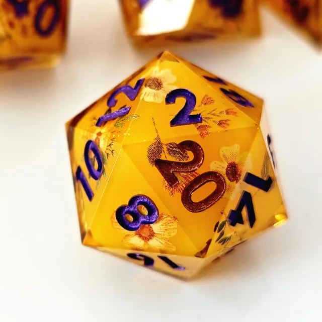 Close-up of honey-gold floral D20 with purple and copper-toned numerals