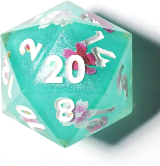 Close-up of a turquoise D20 with white numerals and pink floral shapes.
