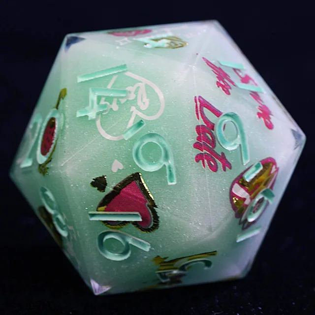 Close-up of a pale mint polyhedral die with raised mint numerals and pink and gold hearts.