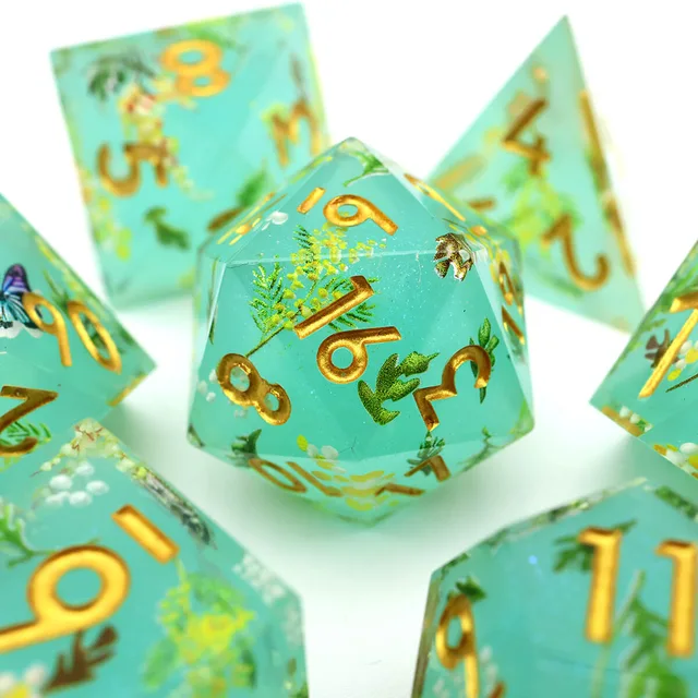 Close-up of an aqua-green floral D20 with gold numbers.
