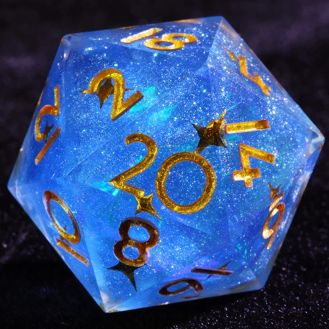 Close-up of a glittering blue D20 with gold numbers and dark star accents.