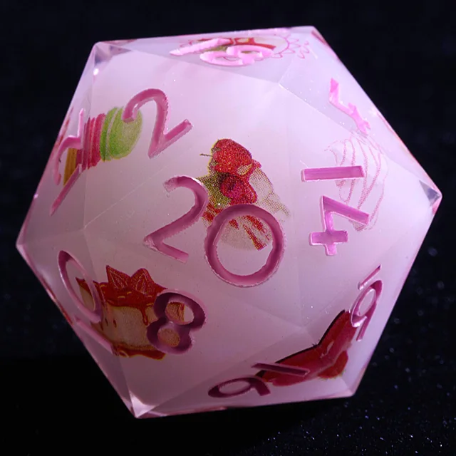 Close-up of a pale pink D20 with pink numbers and colourful dessert illustrations.