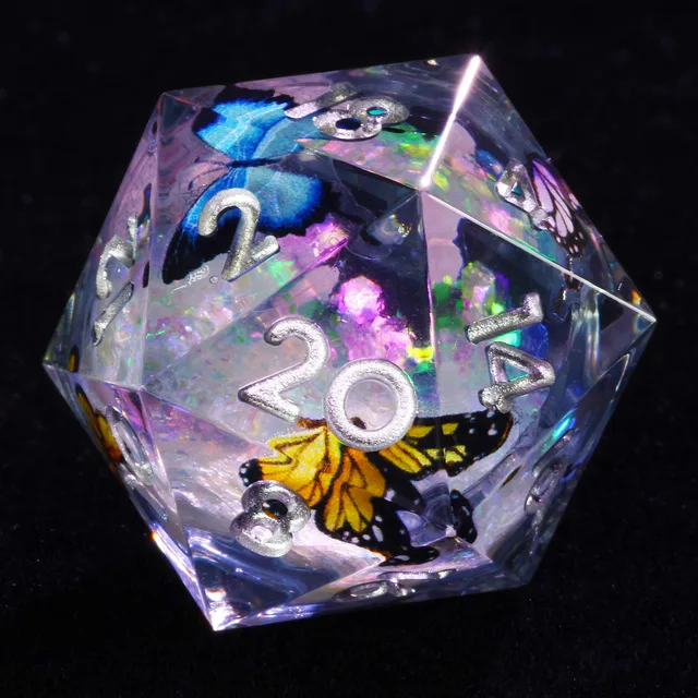 Close-up of a clear D20 with silver numbers and blue and yellow butterflies.
