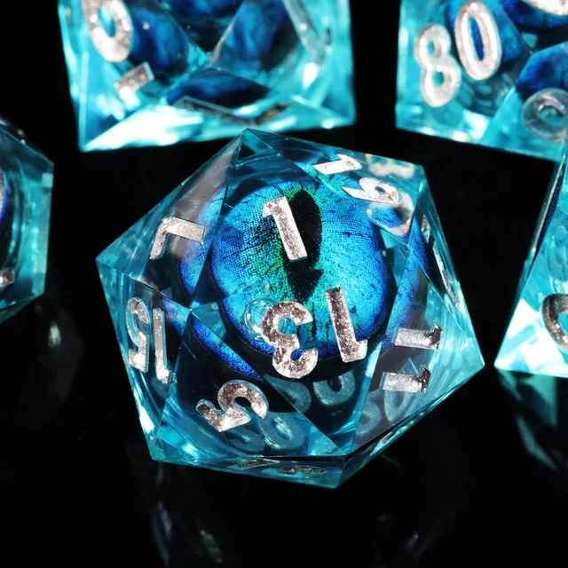 Close-up of an aqua-blue D20 with a blue slit-pupil eye center and silver-coloured numbers.