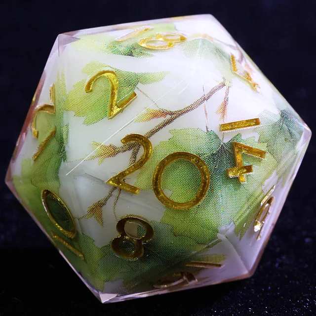 Close-up of a D20 with green maple leaves, branches and gold numbers.