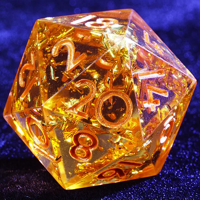 Close-up of an amber-gold D20 with reflective flakes and copper-toned numerals.