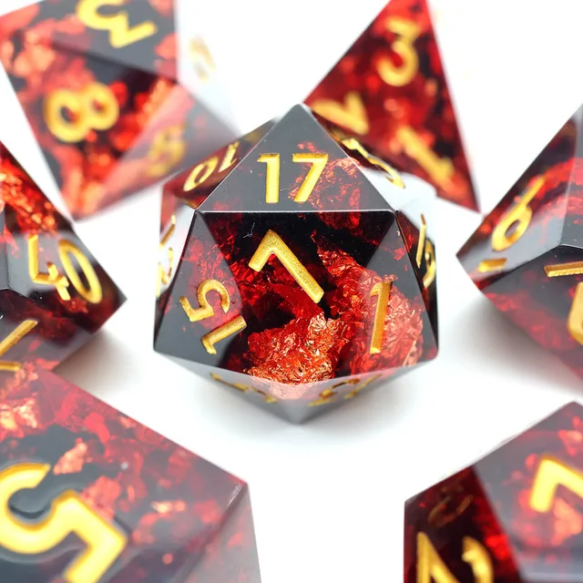 Close-up of a red-and-black D20 with gold numbers.