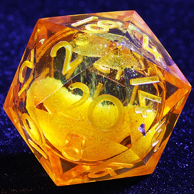 Close-up of a transparent amber D20 with gold-coloured numbers and a glittering golden core.