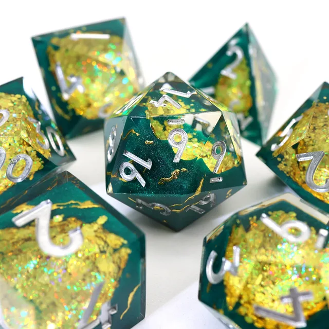 Close-up of a teal-green D20 with gold inclusions and silver numbers.