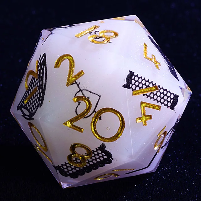Another view of a pale white D20 with gold numbers and black illustrated motifs.