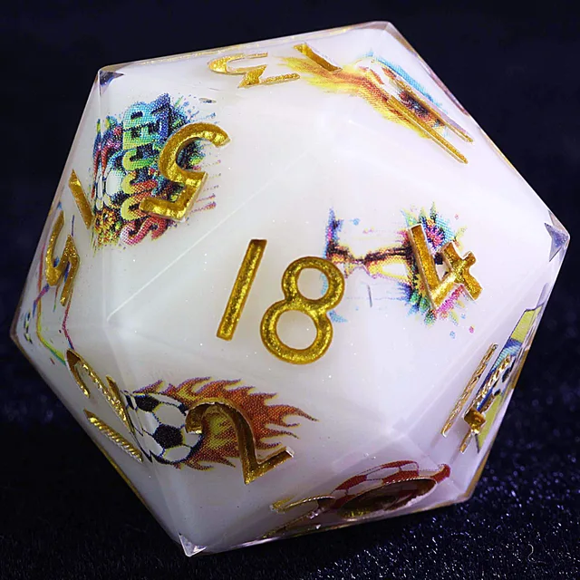 Close-up of a white D20 with gold numbers and colourful football illustrations.