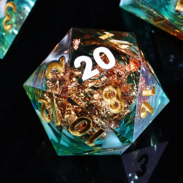 Close-up of a teal-green and amber D20 with copper-coloured inclusions.