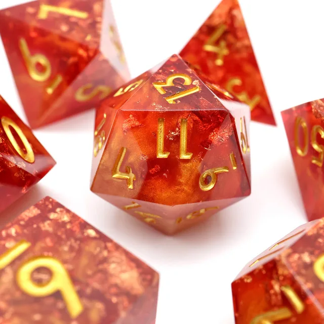 Close-up of a red D12 with gold numerals on white.
