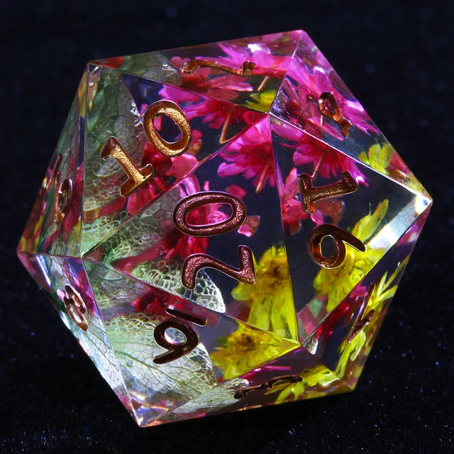Clear D20 with pink and yellow flowers, green leaves and copper-gold numbers on black fabric.